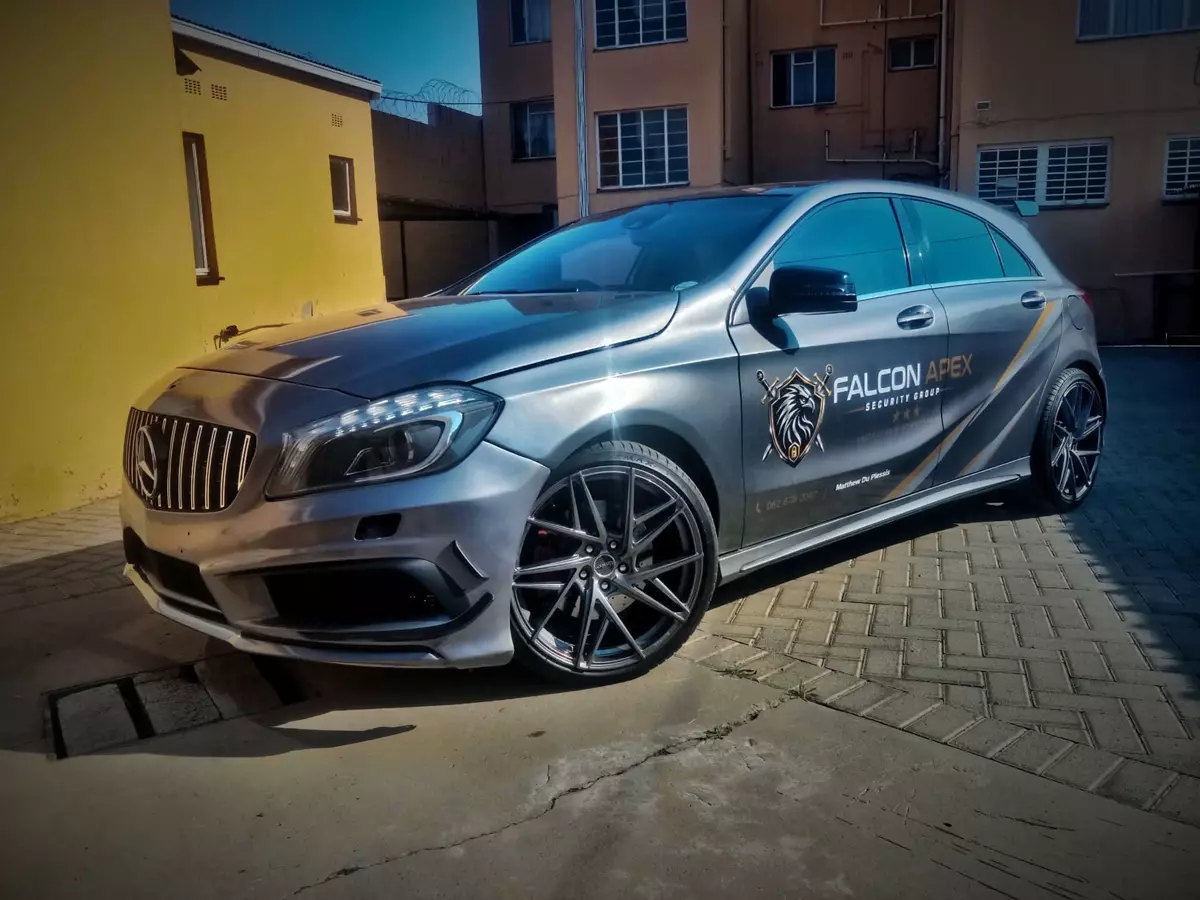 Silver Mercedes-Benz hatchback branded with Falcon Apex Security Group graphics